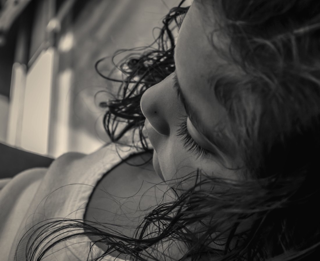 A close portrait of a girl resting, her hair falling across her face